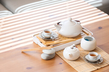 Asian tea set on wooden table in living room, closeup
