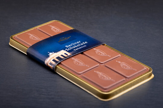 A Berliner Schokolade Vollmilch milk chocolate bar from Lindner Esskultur, a well-known gourmet food brand in Berlin, Germany. The chocolate bar rests in its elegant gold tray with a branded sleeve.