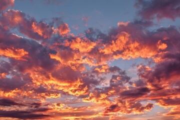 Fototapeta premium Celestial Canvas: The sky erupts in a breathtaking display of fiery hues, where vibrant orange and deep crimson paints the clouds. Witness the majesty of a sunset