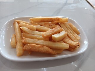 Delicious french fries in plate isolated on white background