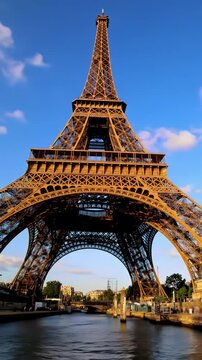 Breathtaking vertical video of Eiffel Tower at golden hour twilight, perfectly mirrored in glassy Seine River, vibrant pastel sky. Aspirational wonder concept