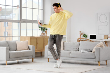 Young man in headphones with laptop at home