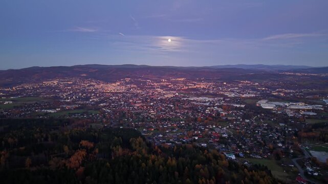 blue hour view of suburban city lights under moon, aerial perspective of residential blocks, soft glow