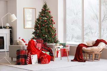 Interior of light living room with sofa, Santa bags and Christmas tree