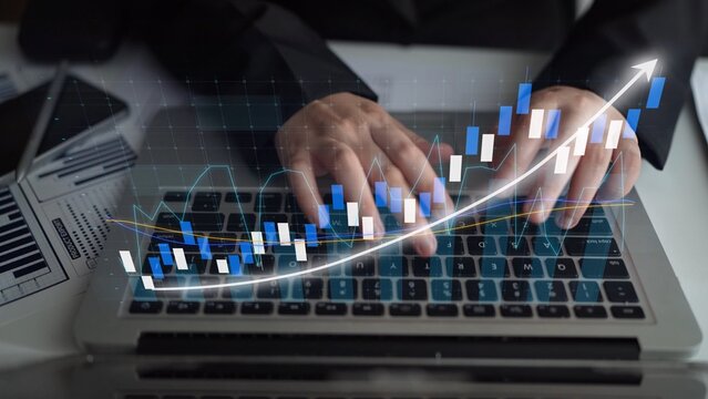 A businessman analyzes financial data on a laptop, with graphs indicating upward trends. This image reflects modern finance, data analytics, and professional growth. Copula - Powered by Adobe