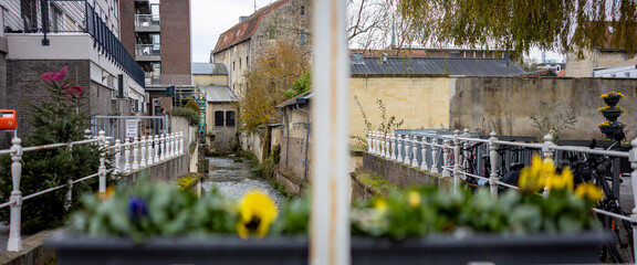 Historic city centre canal Dutch town Valkenburg, The Netherlands, street scene commerce and architecture tourist destination wide angle