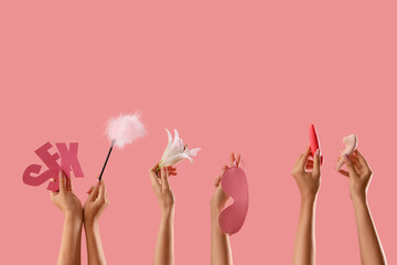 Women with word SEX, flower and toys on pink background
