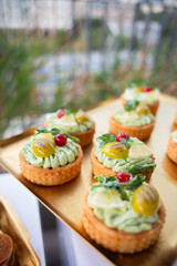 Delicate pastry shells topped with fresh herbs, pickles and berries - perfect for luxury catering, garden parties or gourmet food branding.