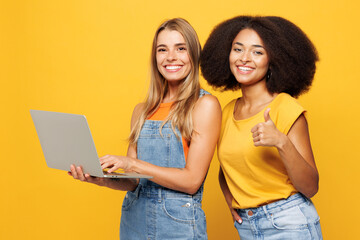 Two young friends buddies IT women wear denim casual clothes together hold use work on laptop pc...