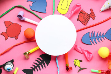 Blank card with paper fishes and party decor on pink background. April Fools Day celebration