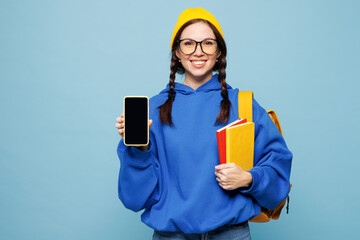 Young smart woman student wear casual clothes bag hold in hand books mobile cell phone with blank screen workspace area isolated on pastel plain light blue background. High college lifestyle concept.