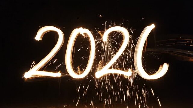 Sparkler light painting of the year 2026 with glowing golden numbers and sparkling embers against a dark background abstract motion blur effect