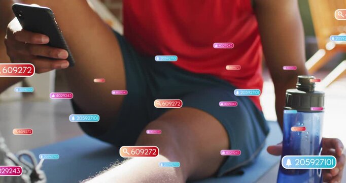 Man scrolling phone on mat, causing alert bubbles flowing over frame, sipping water for fitness