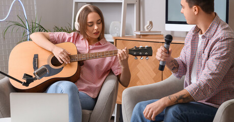 Young couple recording podcast in studio