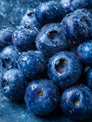 Freshly harvested blueberries with water drops, blue fruit wallpaper for phone.