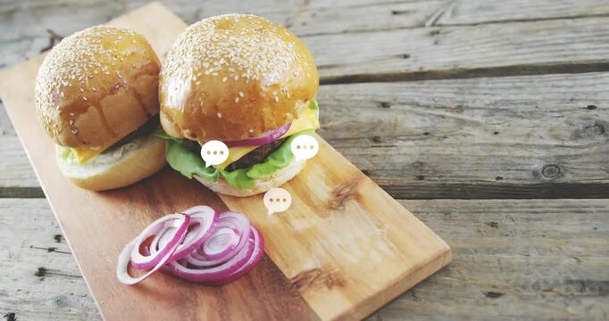 Two cheeseburgers on wooden board, chat bubbles coming from right, clustering fading creating buzz