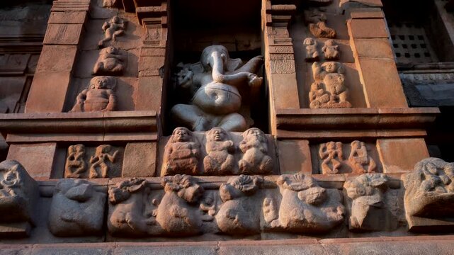 India, Tamil Nadu. 02-11-2025. Close up, Ganesha' s statue in Thanjavur temple at sunset. Tilt 4K