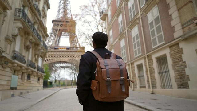 African american tourist walking towards eiffel tower in paris