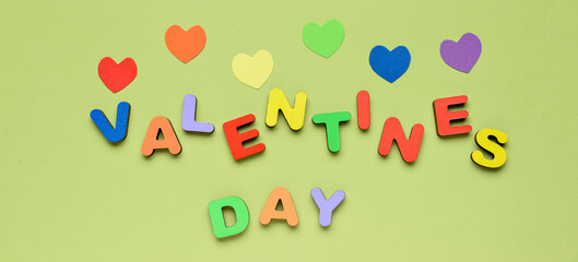 Text VALENTINES DAY with colorful hearts on green background. LGBT concept
