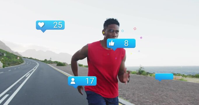 Male runner sprinting toward camera on coastal road, smartwatch syncing and showing fitness badges