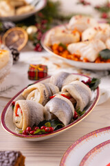 Classic Christmas food medley on a decorated table. Fish, dumplings stuffed with cabbage and mushrooms, cheesecake, and ham.