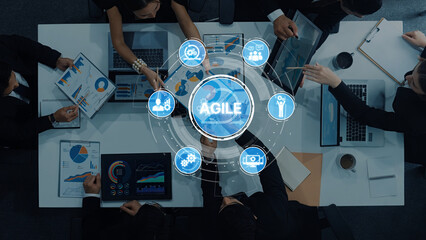 A top-down view of a collaborative business meeting showcasing agile methodology, data analysis charts, and diverse professionals engaged in strategic planning and discussions. Trope