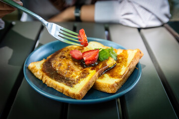 Fork Cutting Strawberry on Sweet French Toast Slices