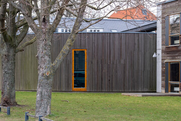 Modern architecture in a Copenhagen urban landscape enhanced by nature, vegetation and green design within an outdoor environment shaped by wooden textures and minimal warm details