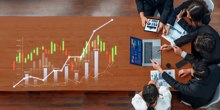 A diverse business team engages in a collaborative analysis of financial data, utilizing charts and technology to deepen their understanding of market trends. Scalp - Powered by Adobe