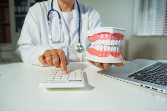 dentists with calculate medical fee costs & revenue. practitioner use calculator at clinic.