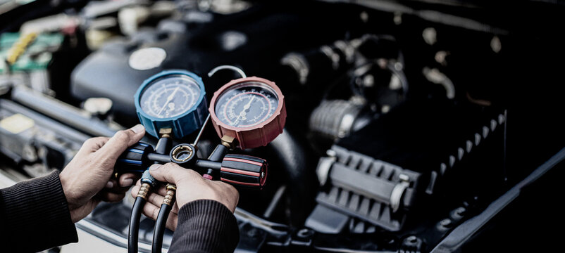 Mechanic Checking Car AC Refrigerant with Manifold Gauge Set