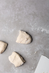 Overhead view of divided chinese scallion pancake dough, top view of chinese pancake dough, process of making cong you bing