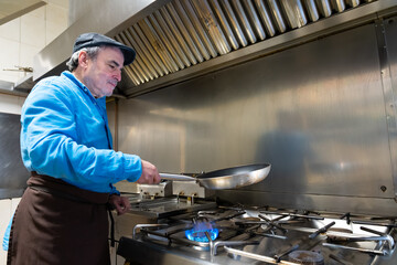 Chef cooking meal in commercial kitchen