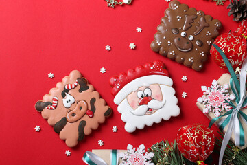 Obraz premium Assorted gingerbread cookies and gifts on red background. Happy New Year. Greeting card. Top view