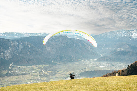 Paraglider taking off from a mountain launch site - Powered by Adobe