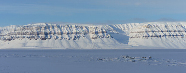 Svalbard. Mountains covered in snow in a frozen fjord