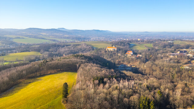 Grabstejn Castle rises majestically on a sunny day, surrounded by lush greenery and rolling hills in Czechia. The sunlight highlights its historical architecture, inviting exploration.