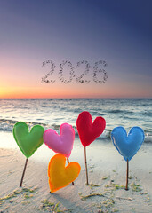 colorful knitted hearts at the beach at new years morning in 2026