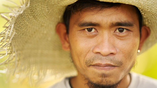 Portrait, young filipino farmer looking serious, man face close up, in straw hat, asian people 