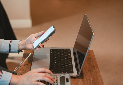 Business woman working on smart phone, laptop and calculator concept for online analyzing financial reports and economic data for business strategy, investment planning and budget management  - Powered by Adobe