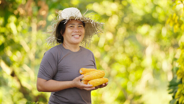 Portrait of smiling filipino woman corn farmer in the philippines, asia, wearing straw hat, looking at camera, asian