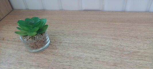 small artificial green plastic flowers on a wooden background