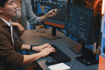 IT developers discussing with point to intelligent website development coder system running data...