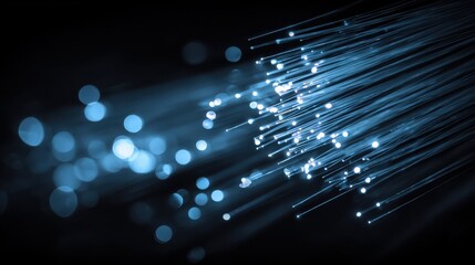 Vibrant blue light beams emit from fine strands, illustrating the beauty of fiber optics in a dark backdrop.