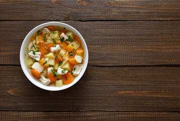 Chicken noodle soup with vegetables in white bowl