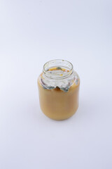 Horizontal top-down photograph of a glass jar filled with apple jam showing visible mold on the upper layer, illustrating food spoilage and contamination.