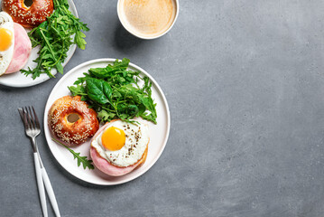 Healthy breakfast. Bagel sandwich with fried egg, ham and greens