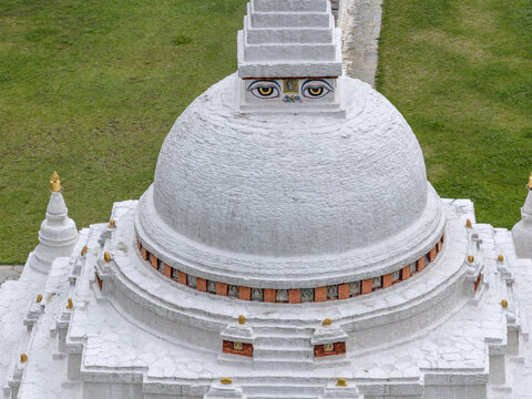 Aerial view of the striking white Chendebji Stupa, adorned with painted eyes, standing out against the green landscape, Chendebji, Trongsa, Bhutan.