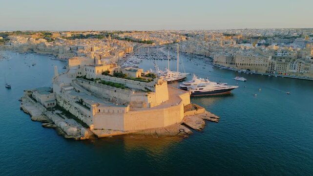 Epic aerial panorama of Fort St. Angelo in Birgu, historic medieval limestone fortress in the Grand Harbour of Valletta, Malta, cinematic 4k drone