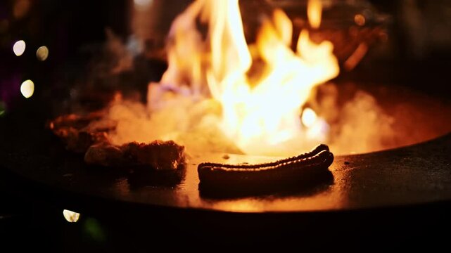 Juicy meat sizzles on steel grill with central flame during winter night market